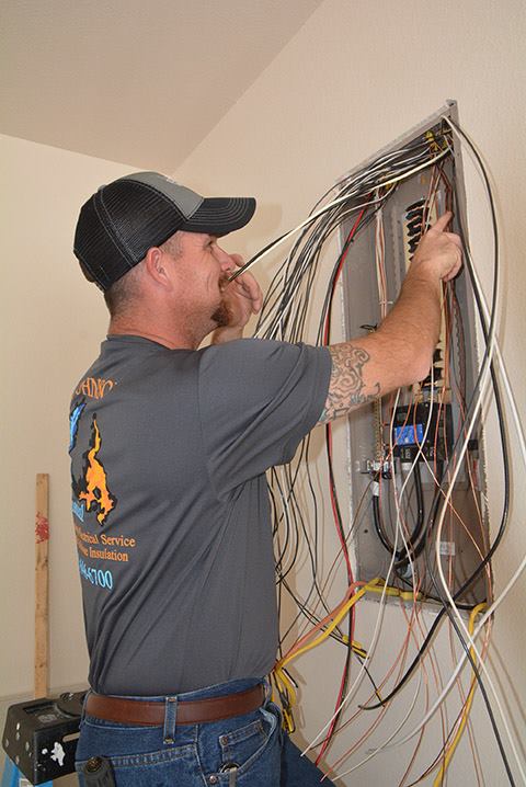 Johnson Mechanical Services electrician wiring a home electrical panel in Brownwood, TX