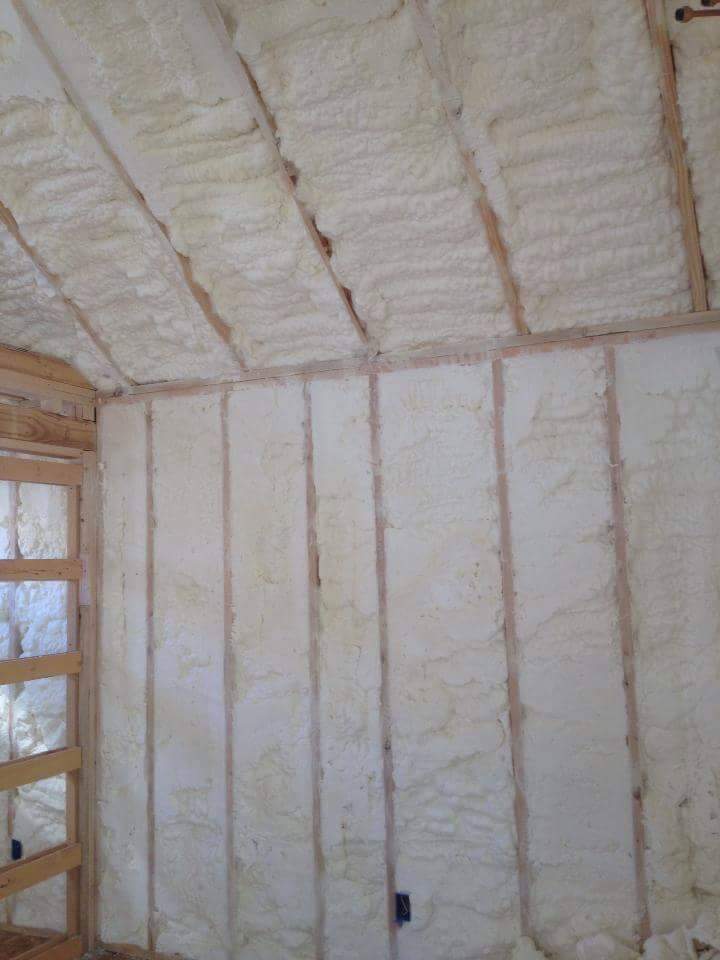Spray foam insulation freshly applied to ceiling and wall framing in a Brownwood, TX home